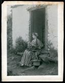 Retrato de uma jovem, na soleira de uma porta, em local não identificado