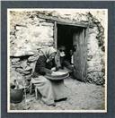 Retrato de uma idosa sentada no exterior junto à porta de uma casa, Freguesia da Camacha, Concelho de Santa Cruz