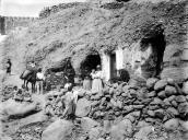 Grupo de pessoas, junto de grutas utilizadas para habitação, em sítio não identificado, na ilha de Gran Canária, arquipélago das Canárias