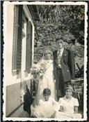Retrato de um grupo de noivos com uma menina e um menino no exterior de uma casa em local não identificado 
