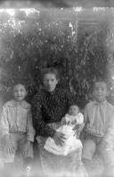 Retrato de exterior de uma mulher adulta, um bebé e duas crianças do sexo masculino (corpo inteiro)