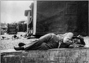 Homem, a dormir sobre um muro, nas proximidades da rua Gago Coutinho (atual avenida do Mar e das Comunidades Madeirenses), Freguesia da Sé, Concelho do Funchal