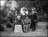 Retrato de grupo de cinco pessoas, fantasiadas, num jardim, em local não identificado