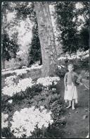 Menina carregando ramos junto a lírios silvestres