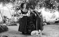 Retrato de duas mulheres com vestuário tradicional e um cão no jardim da Quinta Aluízio, Freguesia de São Pedro, Concelho do Funchal
