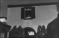 Maria José Bettencourt Gomes da Silva com uma criança na janela do edifício Photographia Vicente, Freguesia da Sé, Concelho do Funchal