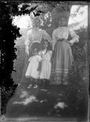 Retrato de duas mulheres e duas crianças, num jardim, em local não identificado