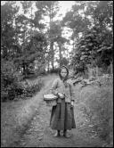 Retrato de uma menina num caminho rural, em local não identificado