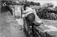 Homem a descansar sobre um muro, na estrada Monumental, Freguesia de São Martinho, Concelho do Funchal