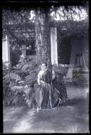 Retrato de uma mulher de traje regional, no exterior de uma residência, em local não identificado, na Ilha da Madeira 