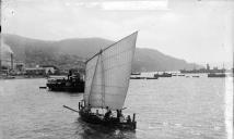Barco de pesca com vela erguida na baía do Funchal