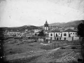 Vista da cidade do Funchal obtida a partir da praia, junto à foz da ribeira de Santa Luzia, enquadrando em primeiro plano o edifício do matadouro municipal e o mercado da fruta e das hortaliças, Freguesia da Sé