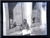 Retrato de uma mulher, sentada no degrau de uma porta, em local não identificado, na Ilha da Madeira