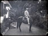 Retrato de homem a cavalo em frente da entrada de uma casa em local não identificado
