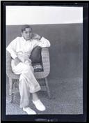 Retrato de um jovem, sentado numa cadeira de vime, em local não identificado, na Ilha da Madeira