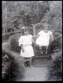Retrato de duas crianças no jardim (corpo inteiro)