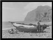 Homem sentado num barco de pesca na praia do Vigário, Freguesia e Concelho de Câmara de Lobos