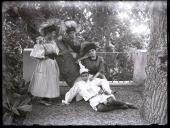 Retrato de três mulheres e um rapaz com disfarces de Carnaval num jardim (corpo inteiro)